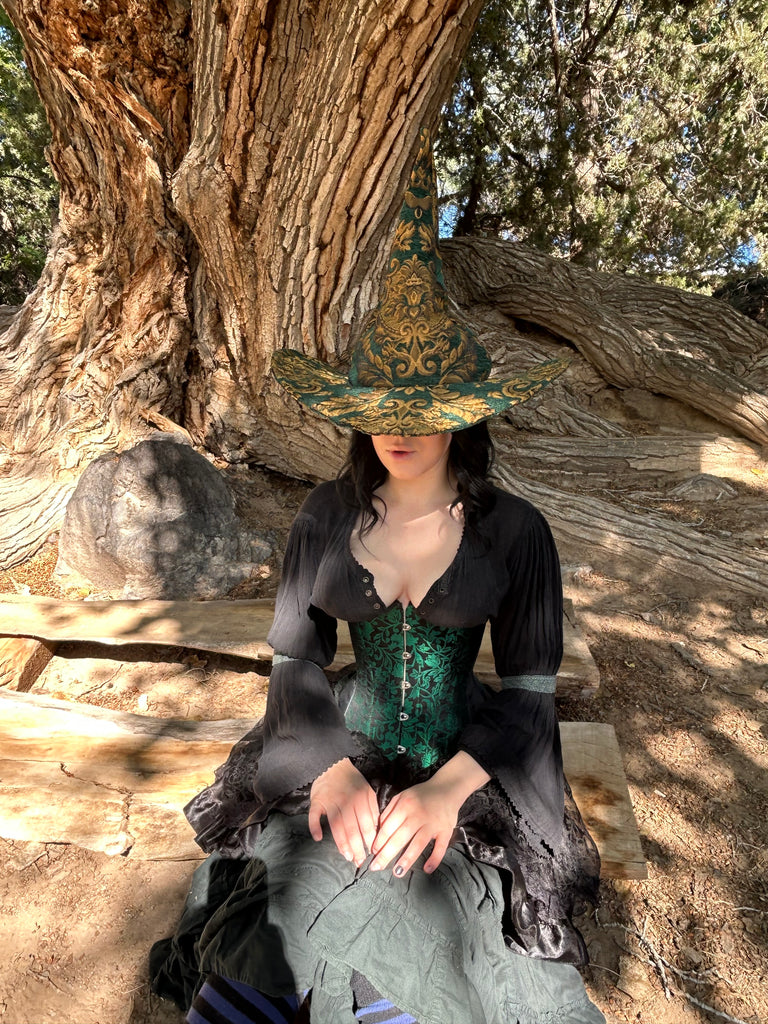 Person sitting under a large tree with a reflective surface showing a mirror image.